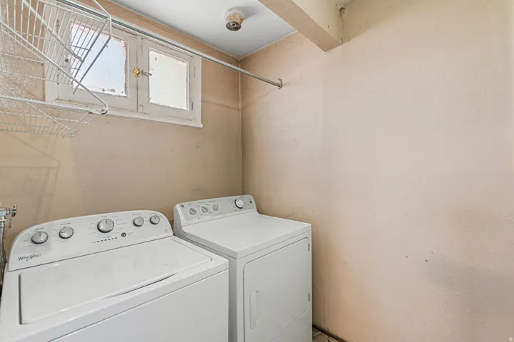Dedicated laundry area featuring a window, overhead shelving, and a clothing rod