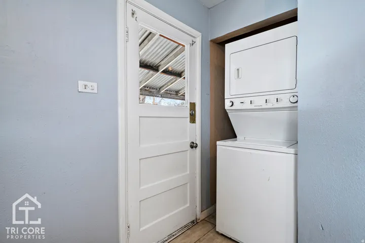 Dedicated laundry area featuring a stacked washer and dryer unit