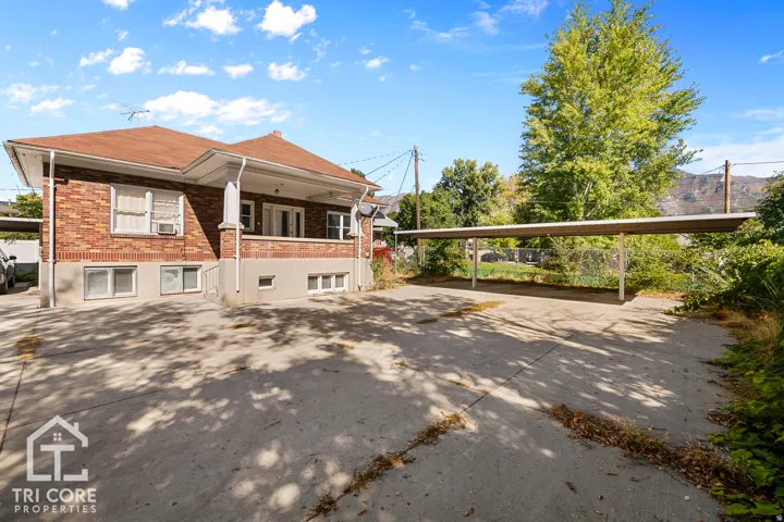 Brick exterior with a covered porch, multiple windows, and a concrete driveway