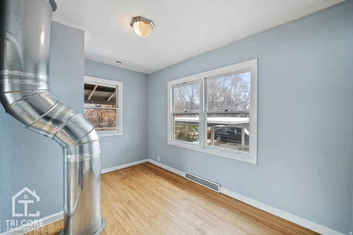 Interior space featuring wood-finish flooring, light blue walls, and white trim