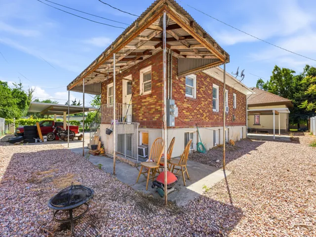 Brick exterior with a covered patio and a separate carport structure