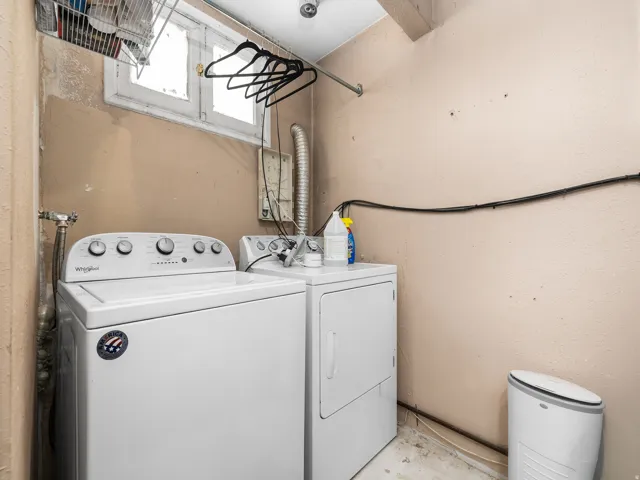 Laundry area featuring a top-load washing machine, front-load dryer, and a high window