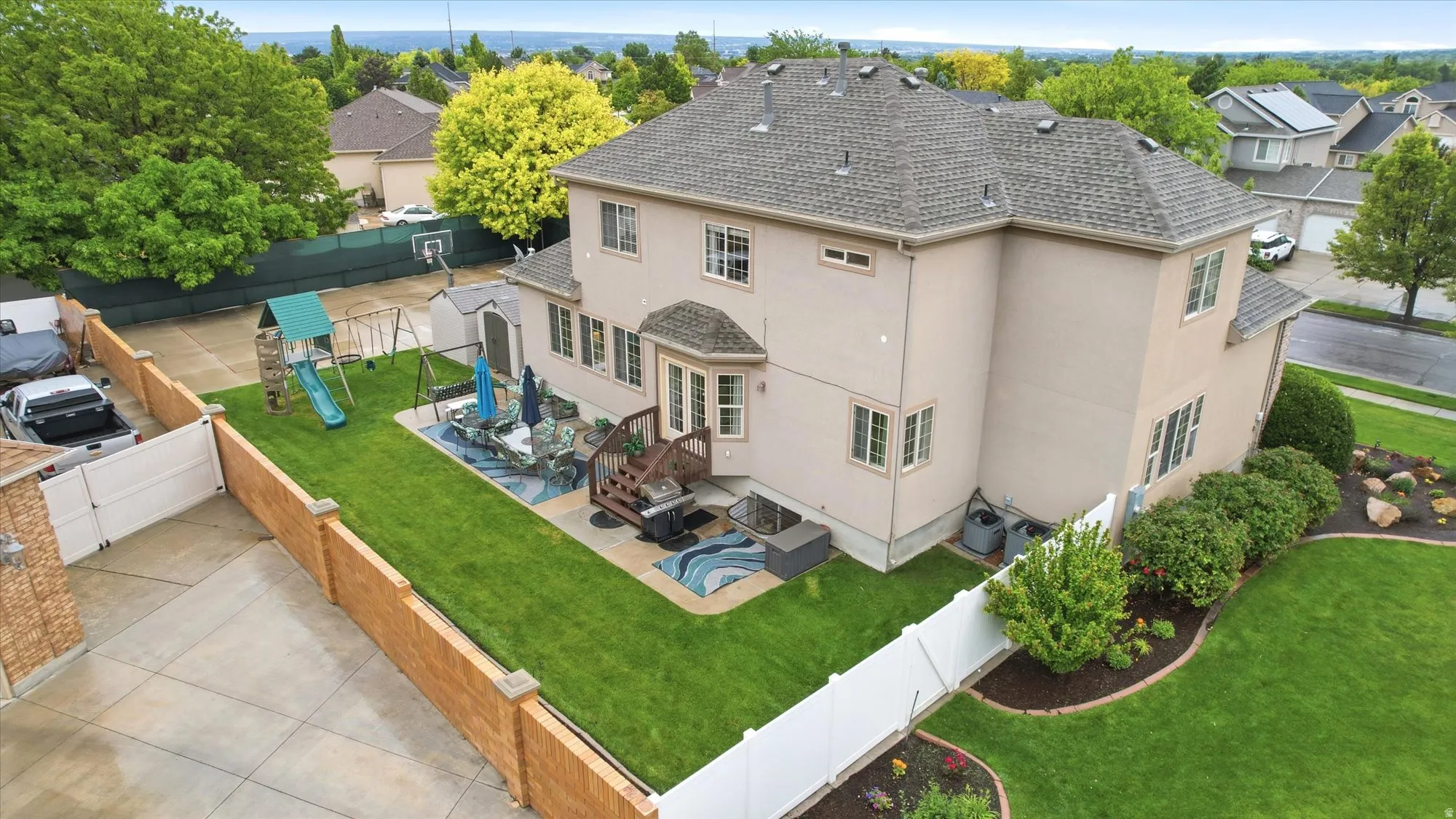 Expansive two-story stucco residence with a multi-level deck and a concrete patio