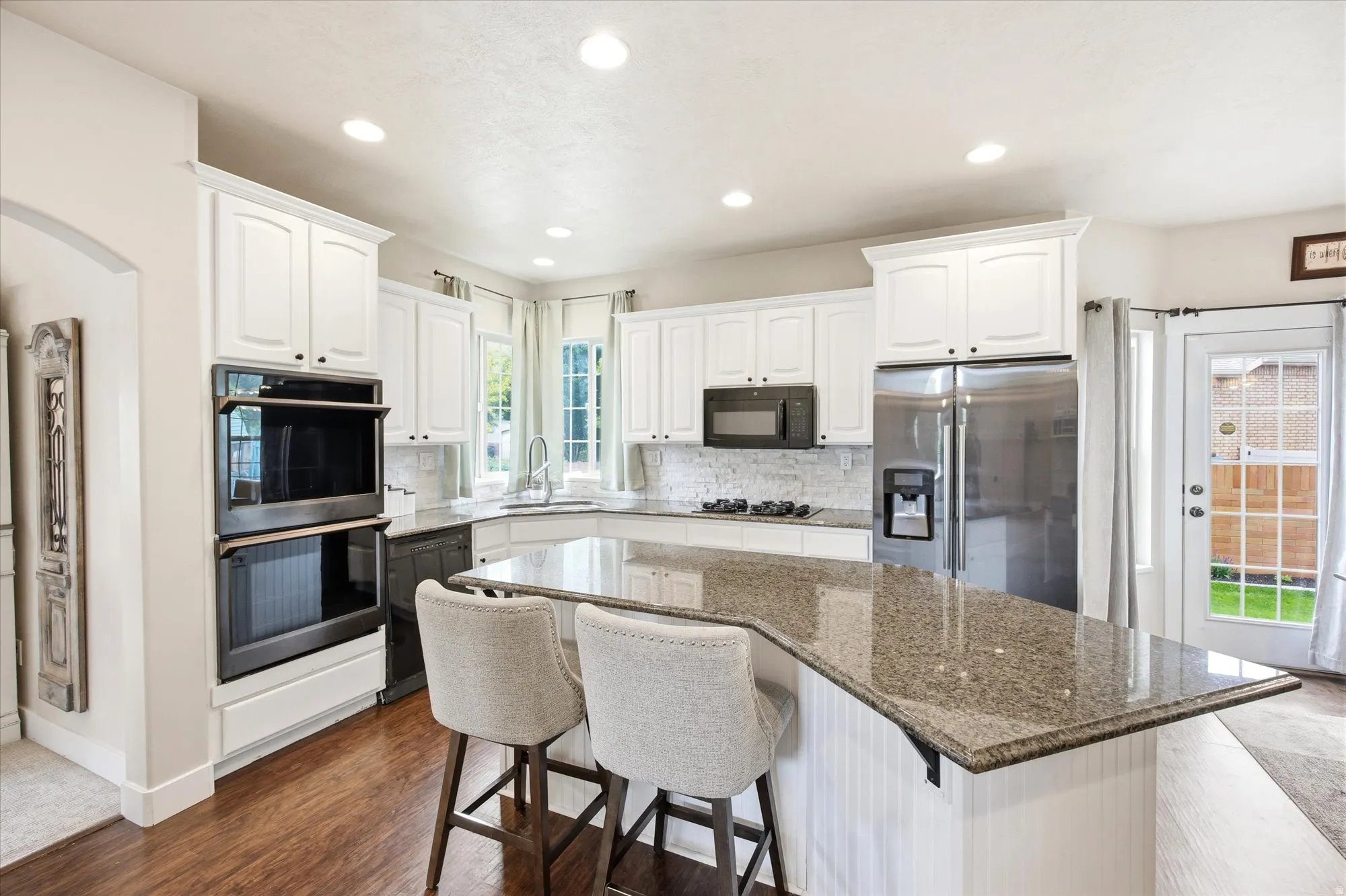 Bright kitchen featuring wood-finish flooring and recessed lighting