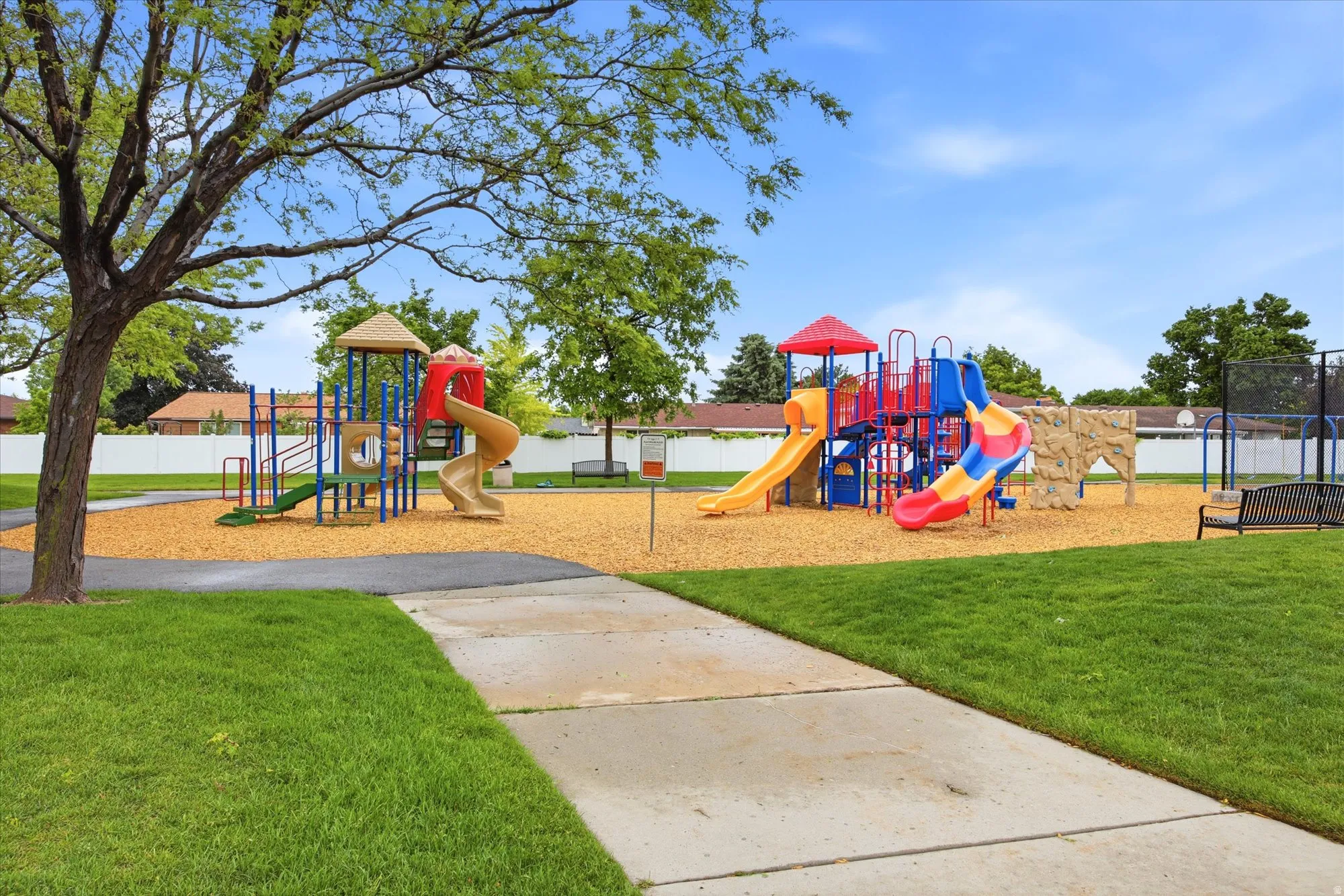 Recreational playground area featuring multiple slides, climbing structures, and a wood chip surface