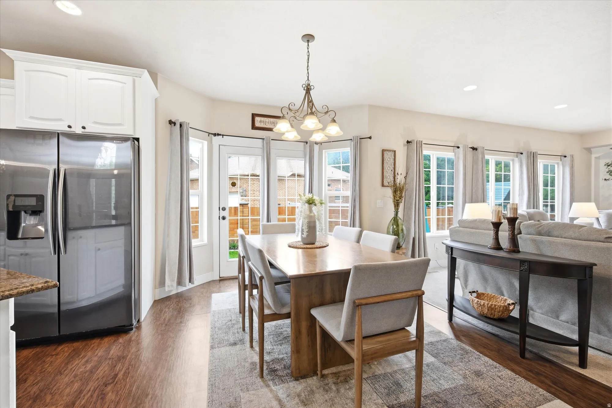 Open-concept living area featuring wood-finish flooring, recessed lighting, and multiple windows