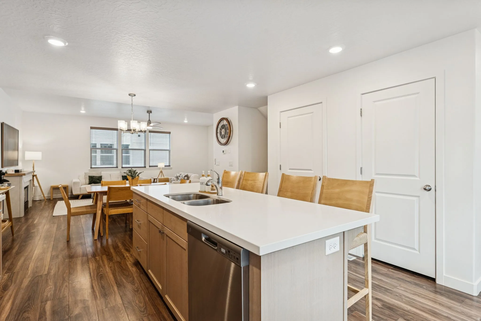 Kitchen island featuring a double-basin stainless steel sink, integrated stainless steel dishwasher, and a light-toned countertop