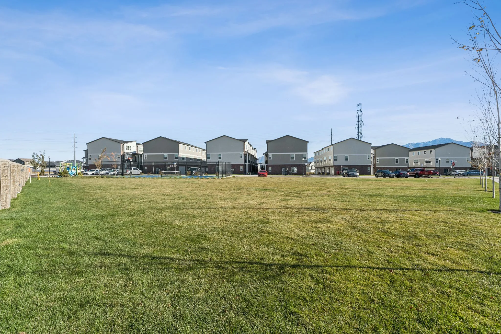 Expansive green space featuring a manicured lawn and mature trees