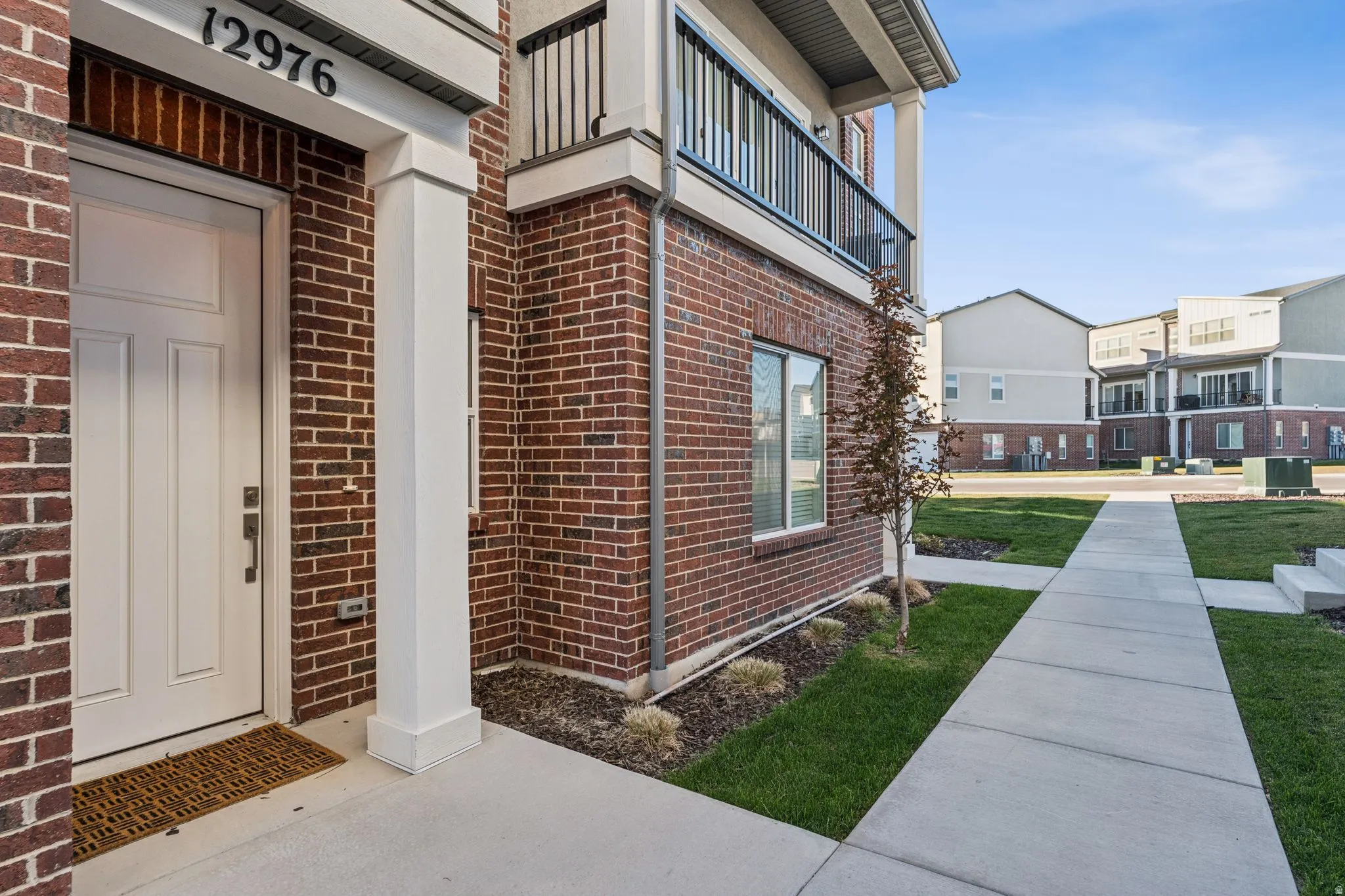 Brick exterior featuring a white paneled entry door with dark hardware