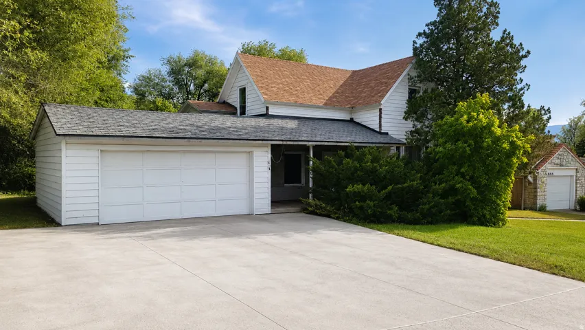 Concrete driveway leading to an attached two-car garage with white panel doors