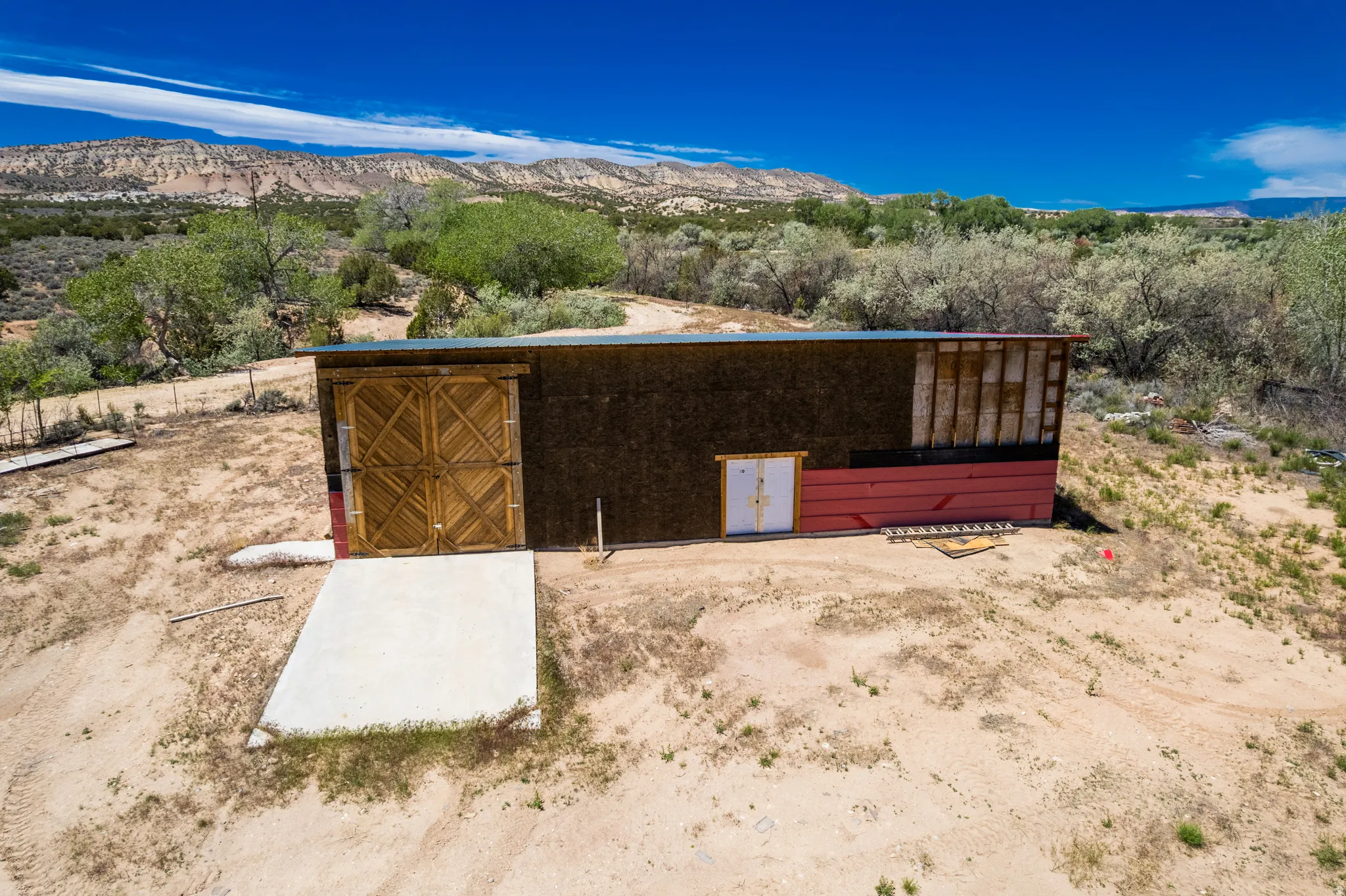 Building with wood-finish double barn doors and a raw wood panel exterior