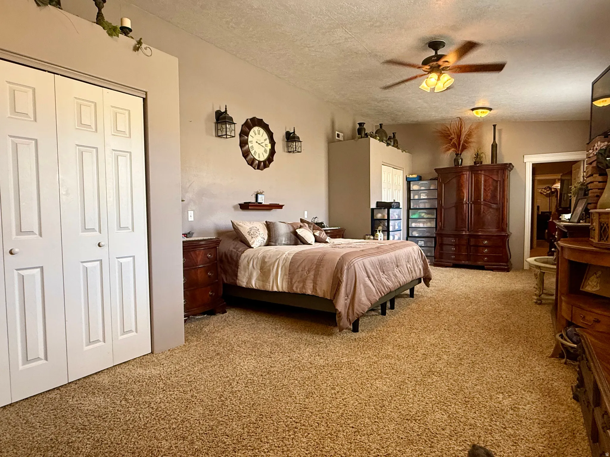 Carpeted room featuring bi-fold closet doors, a ceiling fan with integrated lighting, and recessed shelf space