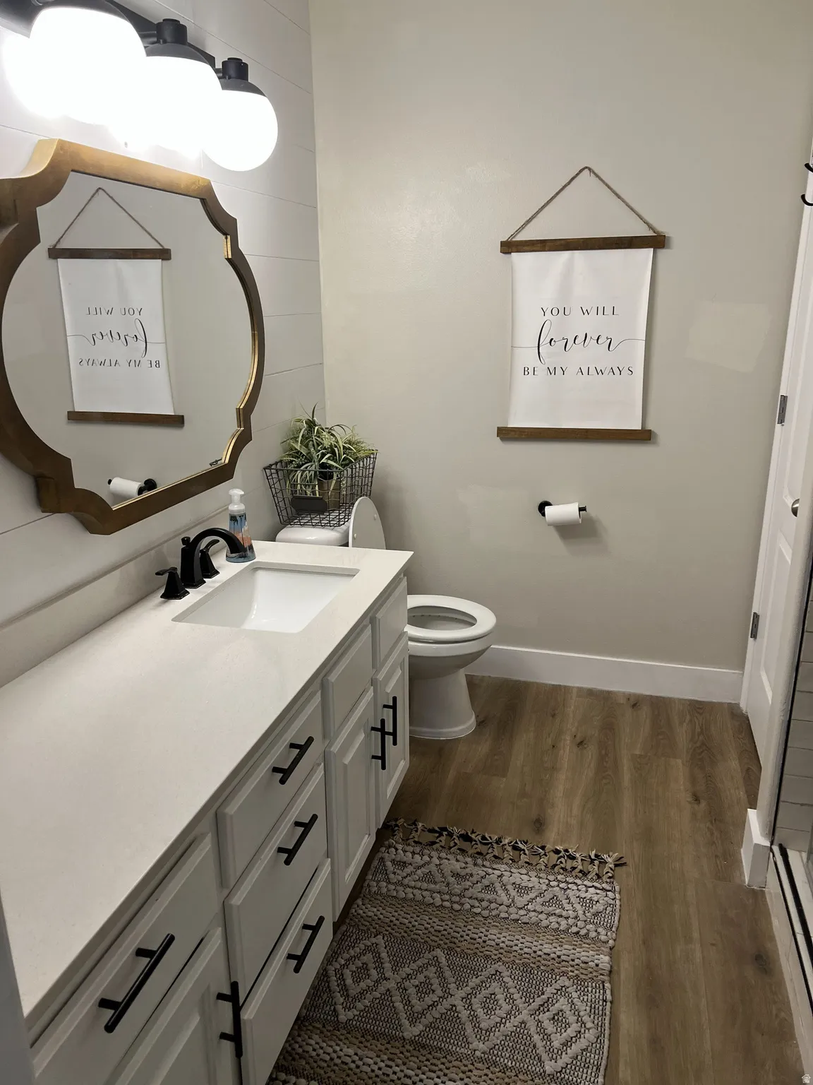 Bathroom featuring a single vanity with white cabinetry, matte black hardware, and a white countertop