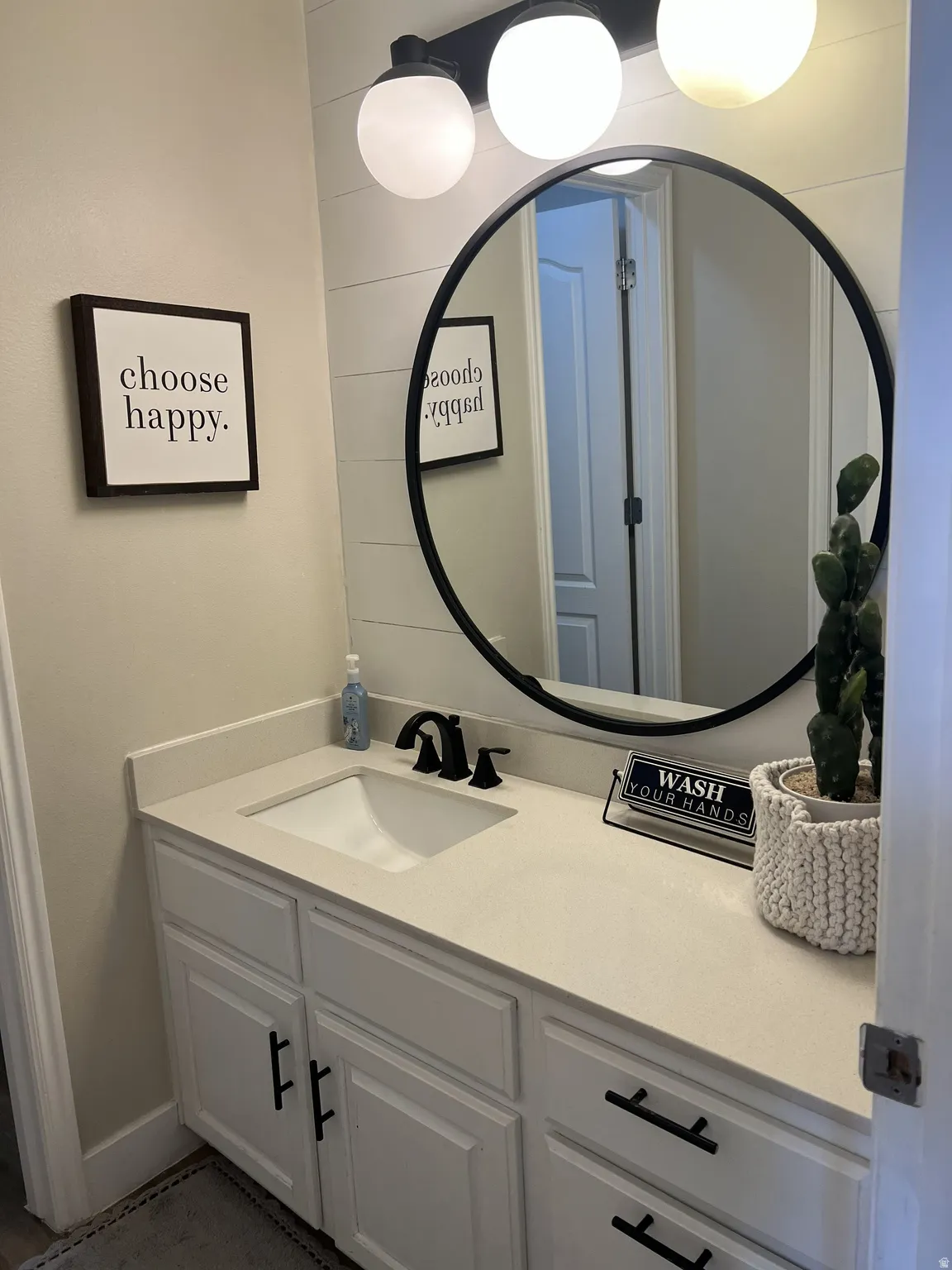 Vanity featuring a white countertop, integrated sink, and matte black faucet