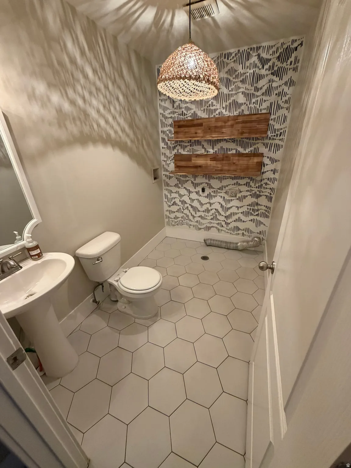 Hexagonal floor tiling and a pedestal sink