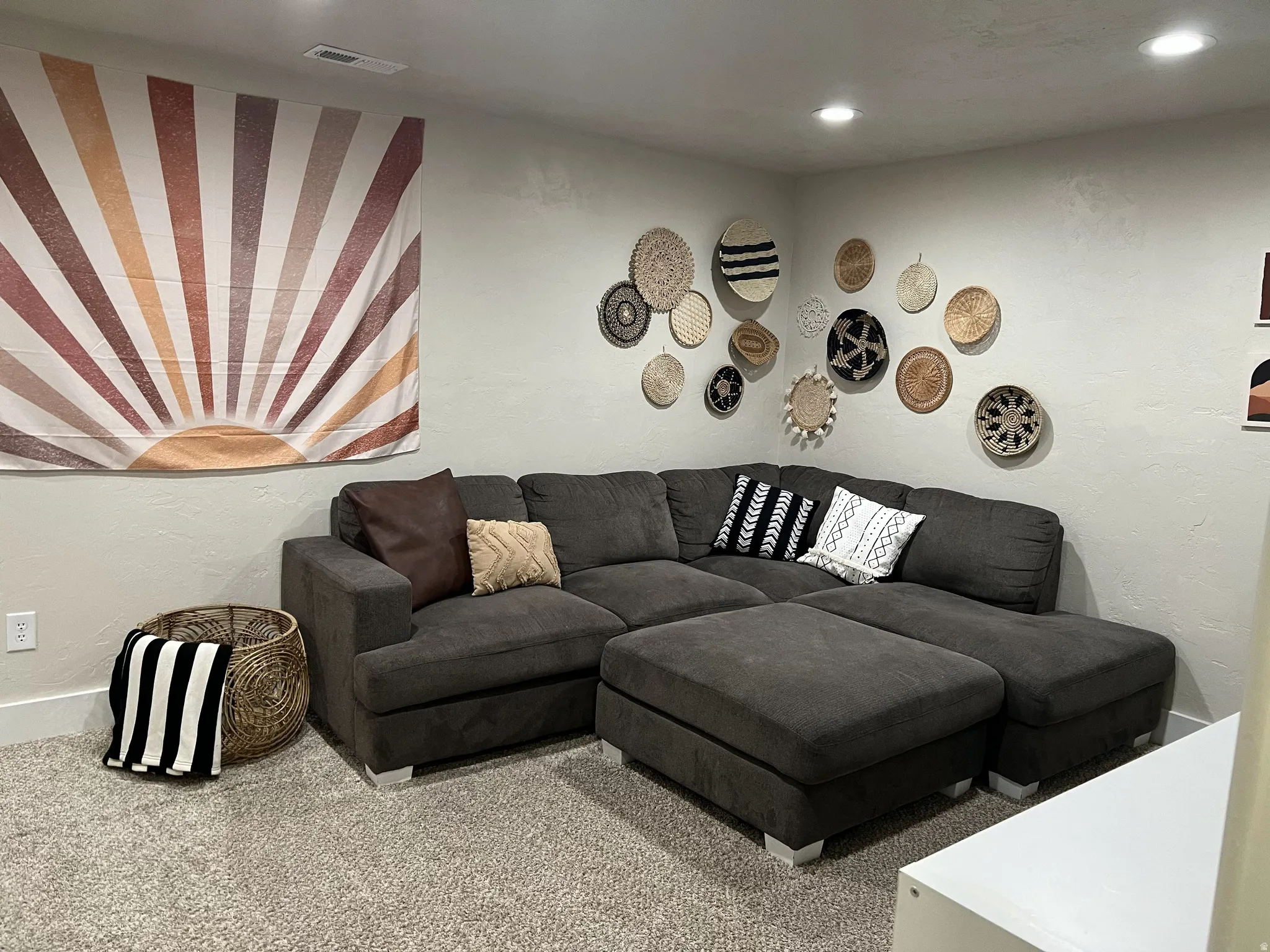 Recessed lighting illuminates the carpeted living space