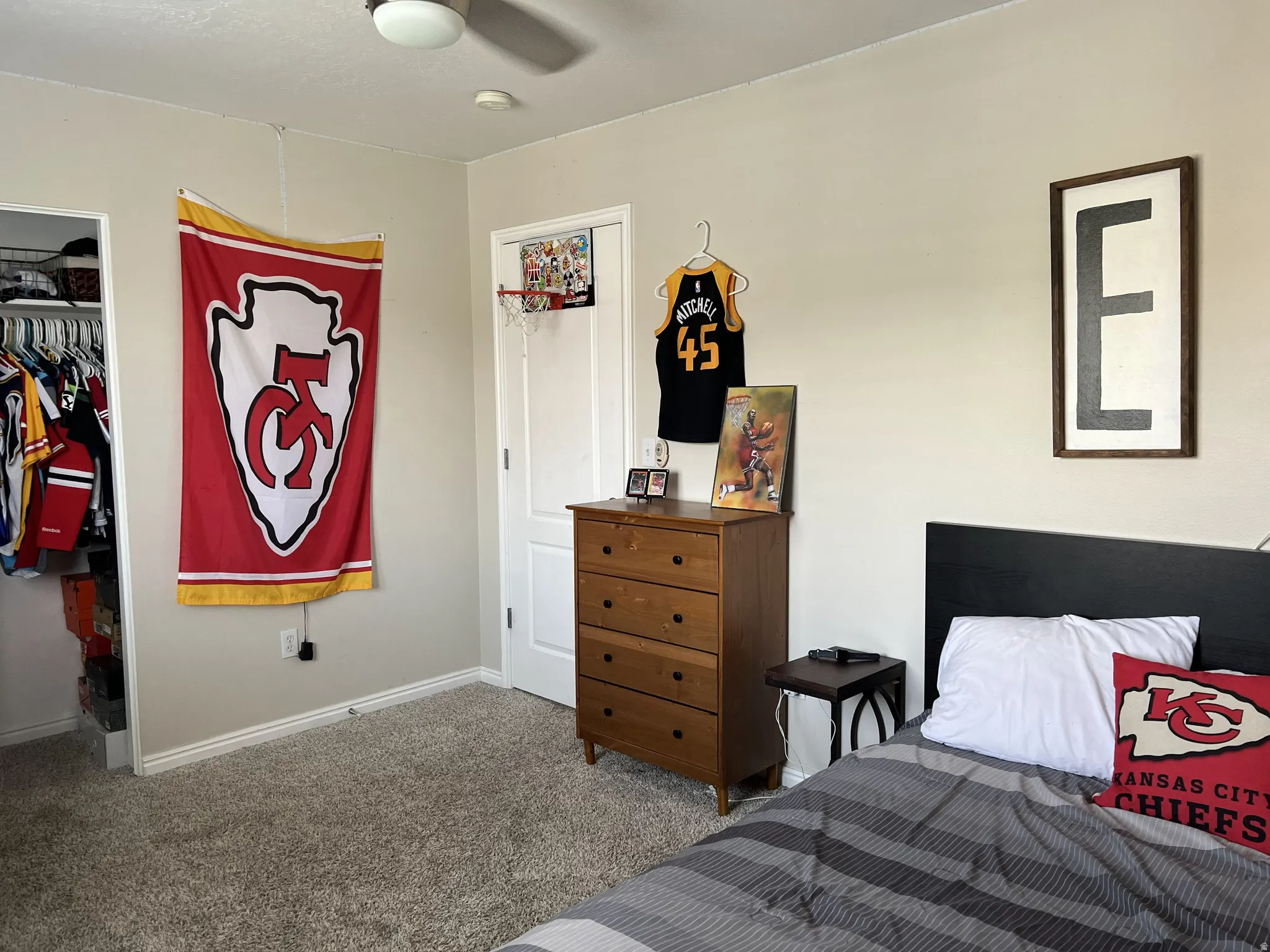 Carpeted room featuring a ceiling fan, built-in closet with bifold door, painted walls, and white trim