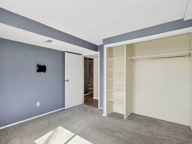 Bedroom featuring gray carpet flooring, blue painted walls, and white trim