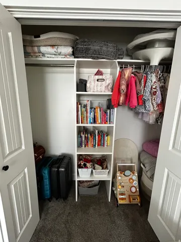 Double bifold doors opening to a built-in closet system