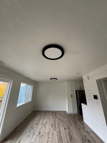 Interior space featuring wood-finish flooring, white walls, and two large windows