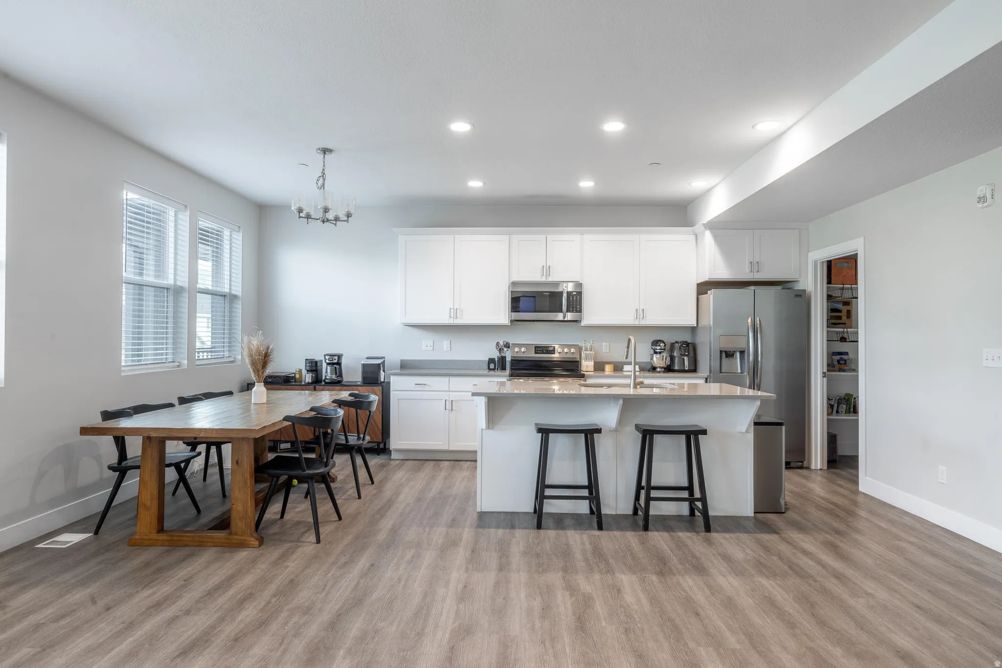 Open-concept kitchen and dining area featuring light wood-finish flooring