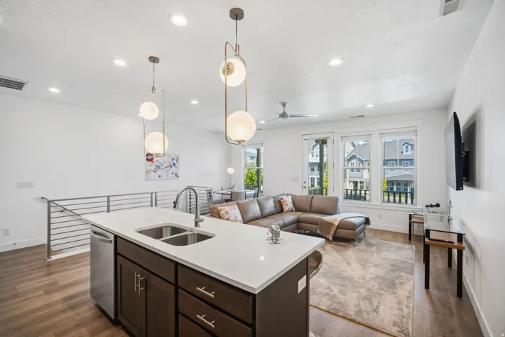 Second-floor living area featuring a kitchen island, an access to the front deck, and stairs down to the main level.