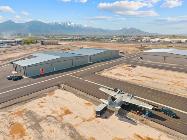 Large hangar facilities with expansive asphalt runways and distant mountain backdrop