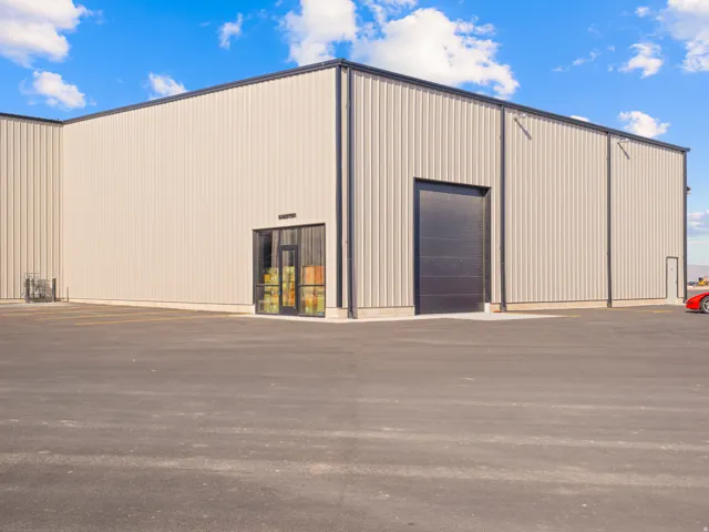Industrial building featuring a corrugated metal exterior and a black roll-up door