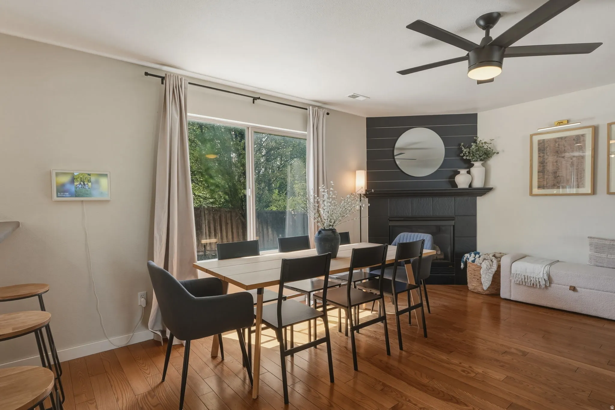 Hardwood flooring throughout the dining area, featuring a black shiplap accent wall with a fireplace and mantel