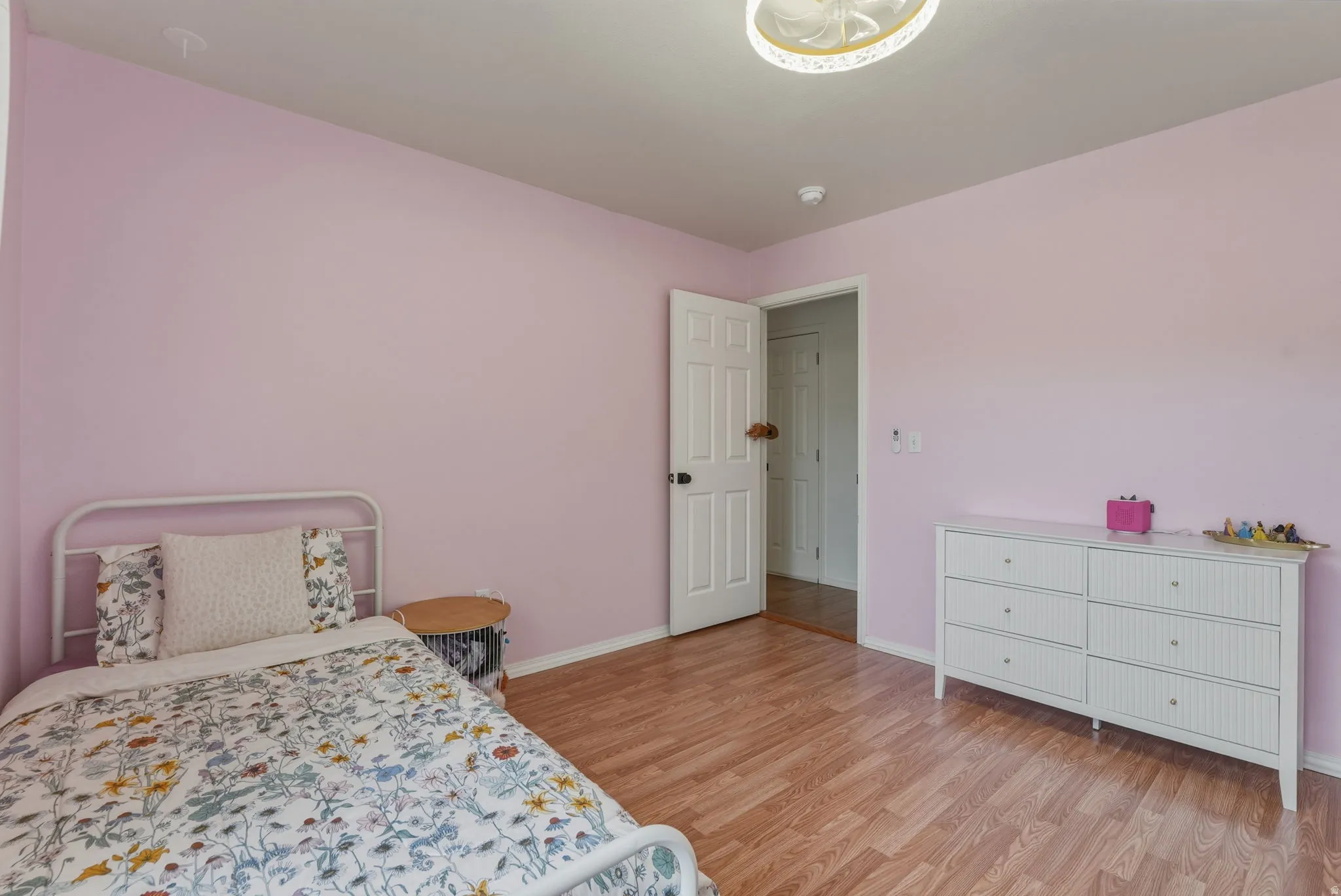 Interior room featuring wood-finish flooring, a white paneled door, and a built-in closet visible through the doorway
