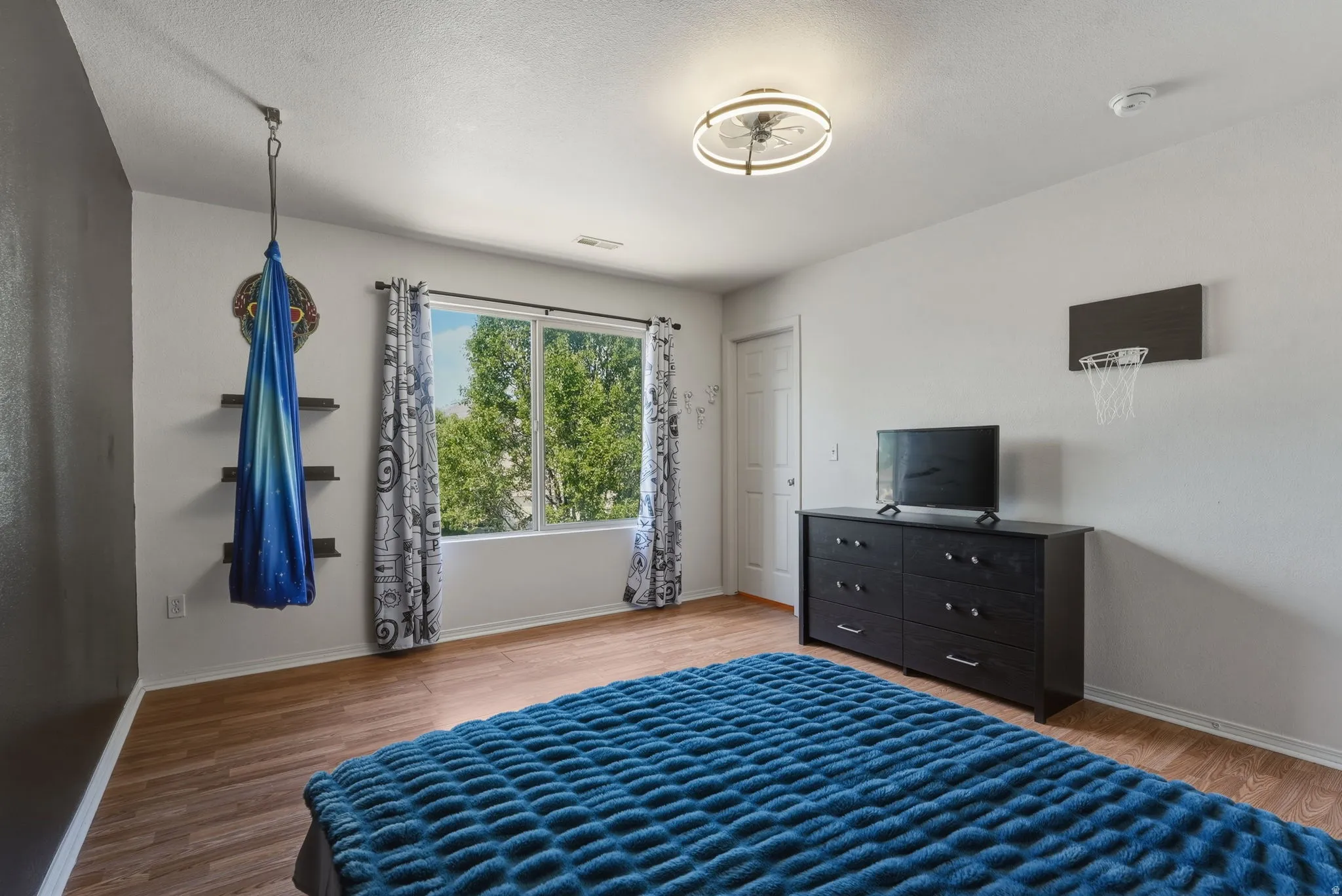 Spacious room featuring wood-finish flooring and a large window