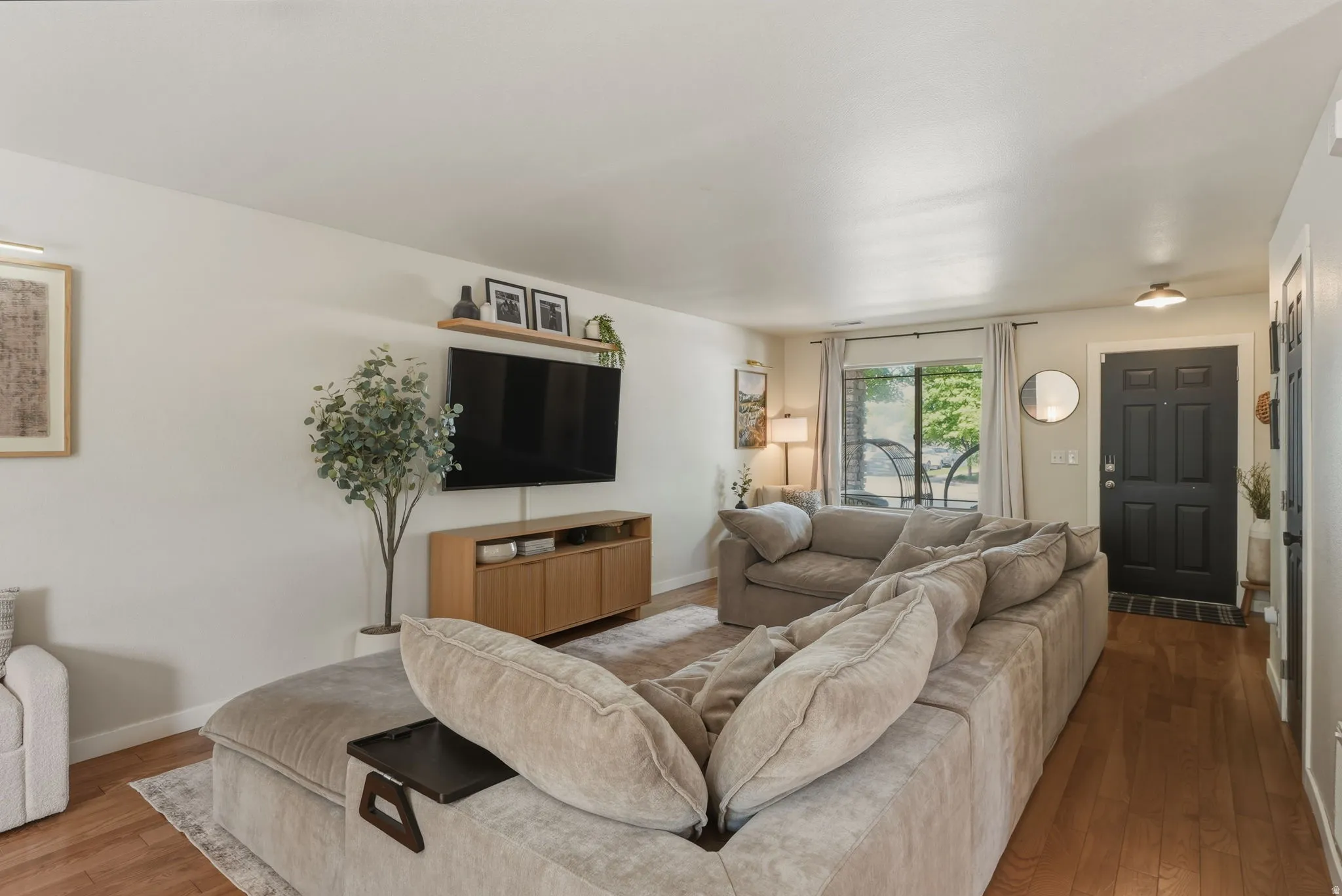 Open-concept living area featuring wood-finish flooring and light neutral wall colors