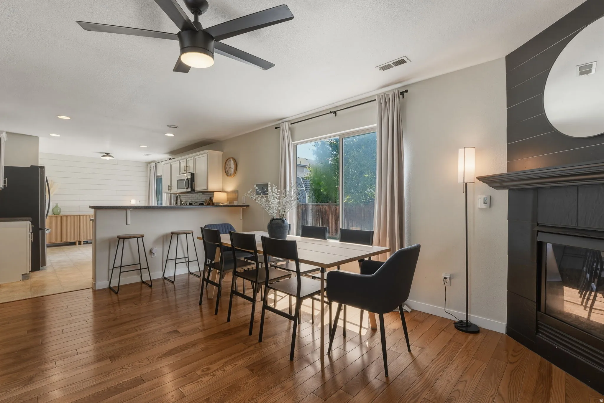Open-concept dining area featuring wood-finish flooring and a ceiling fan