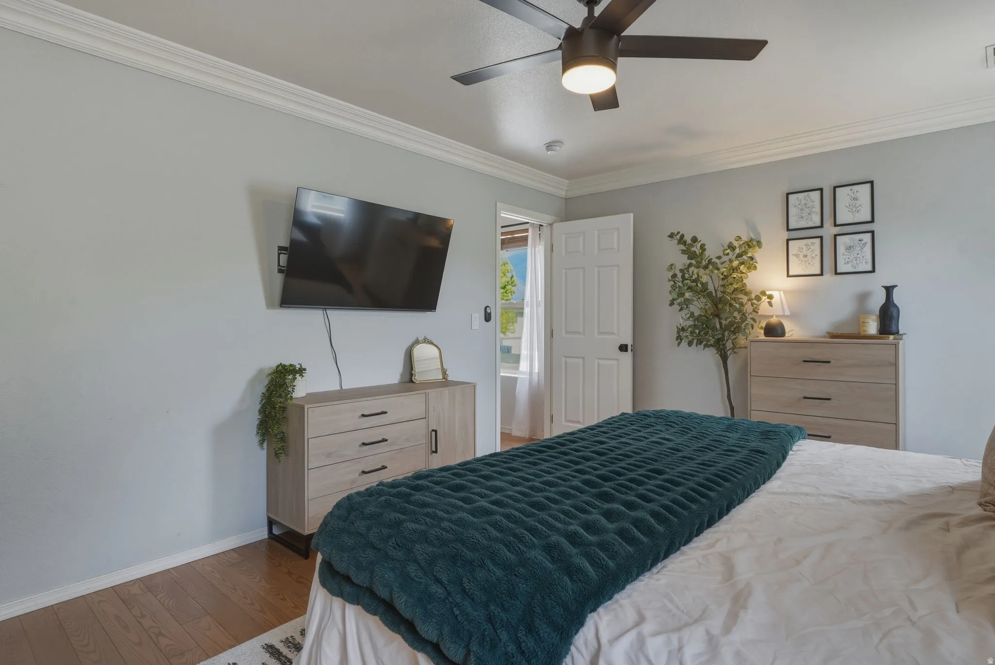Bedroom featuring crown molding and wood-finish flooring