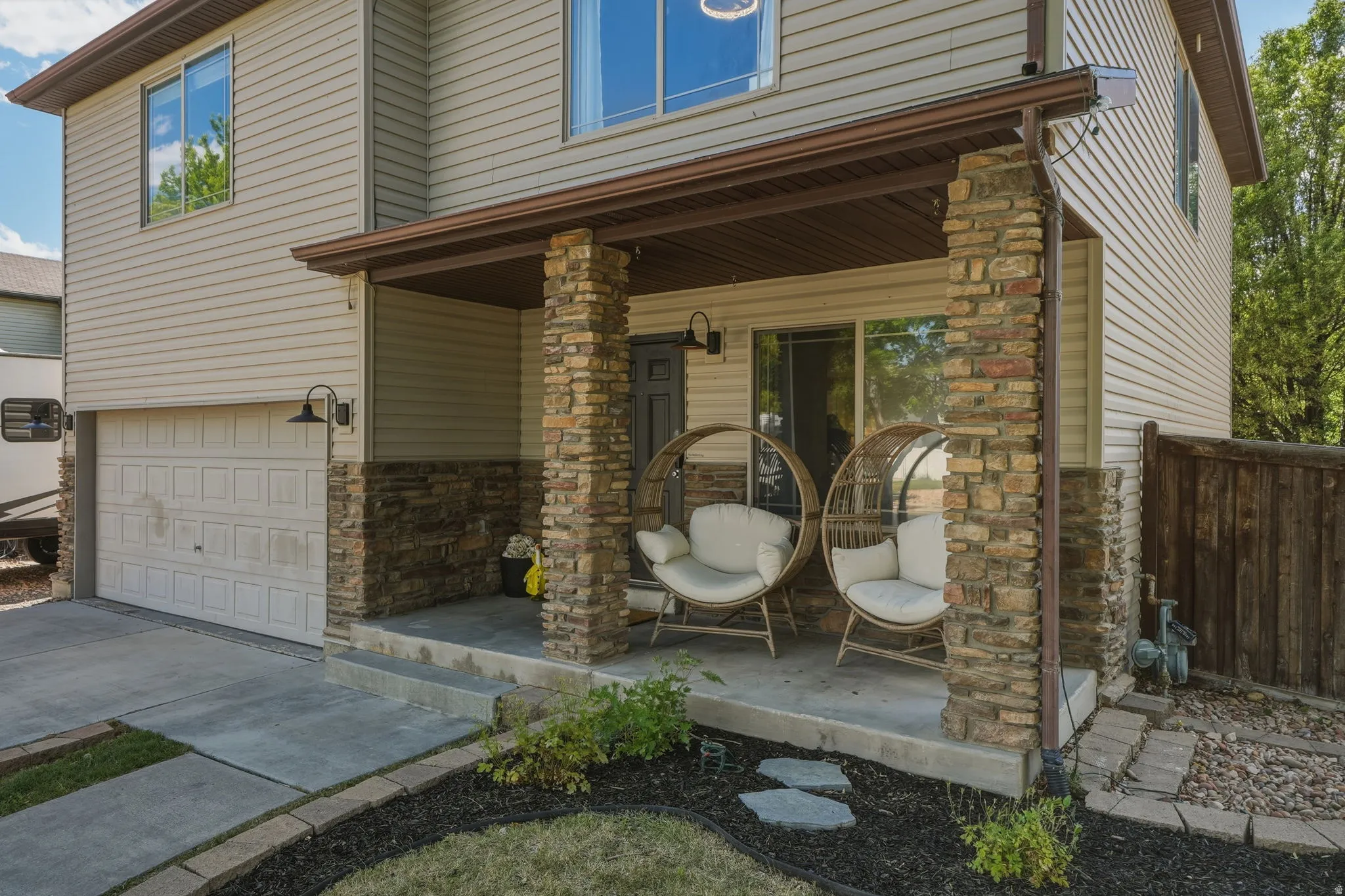 Stone-clad porch with concrete flooring and a dark brown overhead awning
