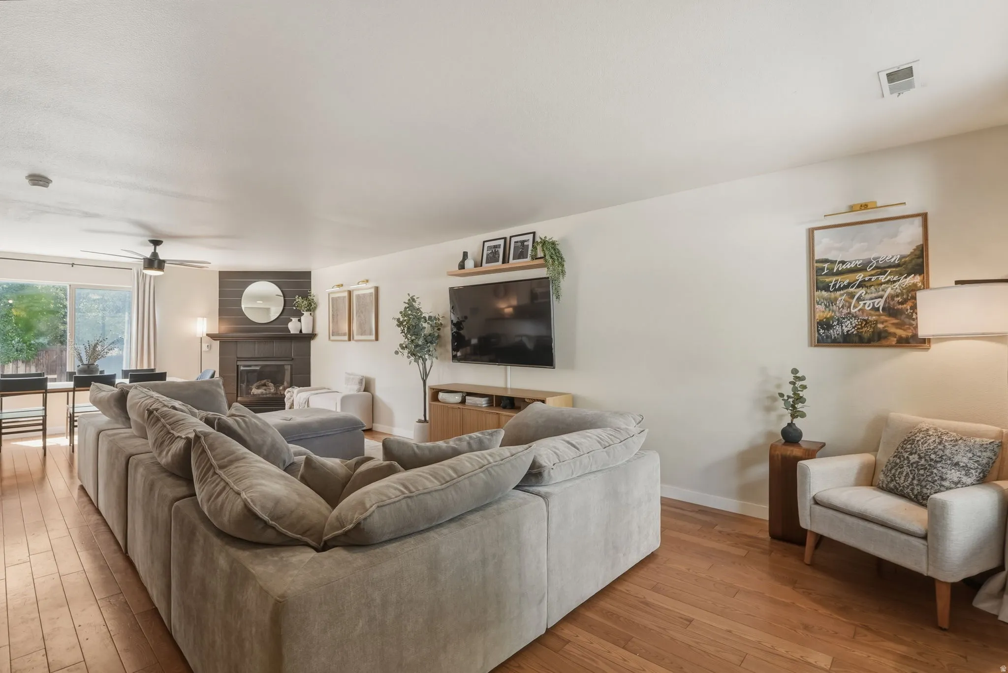 Open concept living space featuring wood-finish flooring, a fireplace with dark shiplap surround, and recessed lighting