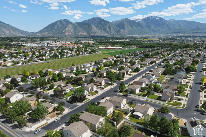 Expansive aerial showcasing a residential neighborhood with detached homes, mature trees, and paved roads