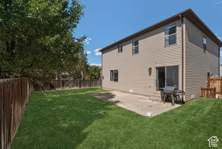 Expansive grassy yard with a privacy fence and mature trees