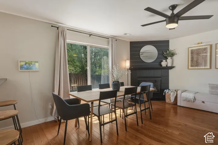 Hardwood flooring throughout the dining area, featuring a black shiplap accent wall with a fireplace and mantel