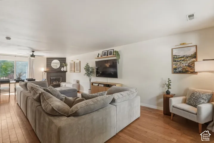 Open concept living space featuring wood-finish flooring, a fireplace with dark shiplap surround, and recessed lighting