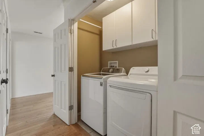 Dedicated laundry area featuring white upper cabinetry, a utility sink hookup, and neutral wall tones