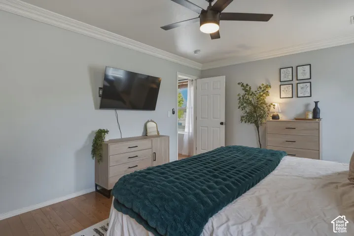 Bedroom featuring crown molding and wood-finish flooring