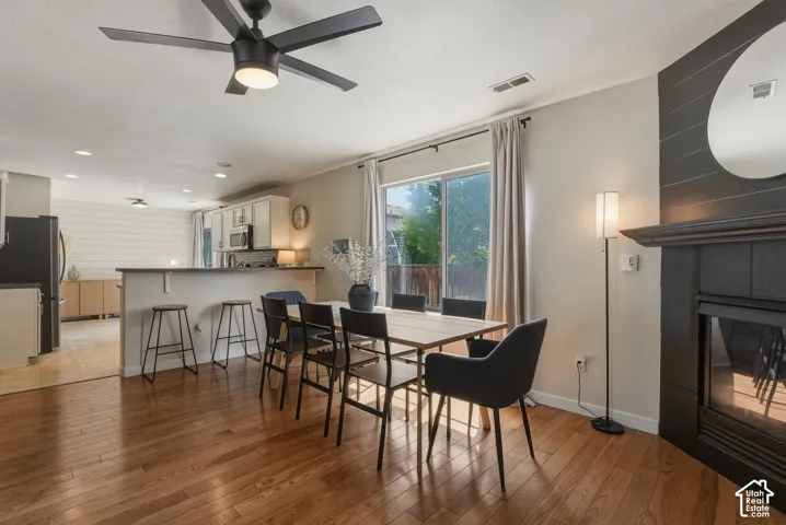 Open-concept dining area featuring wood-finish flooring and a ceiling fan