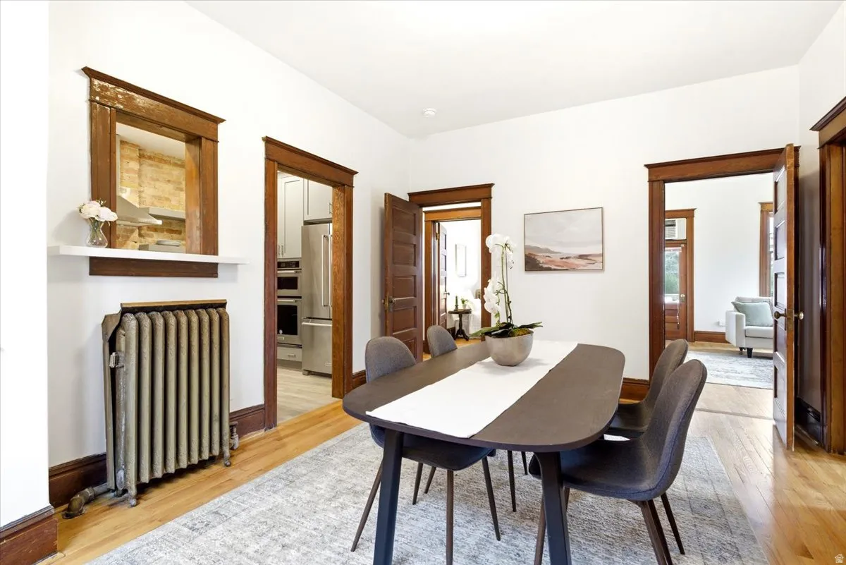 Dining area featuring wood-finish flooring and white walls