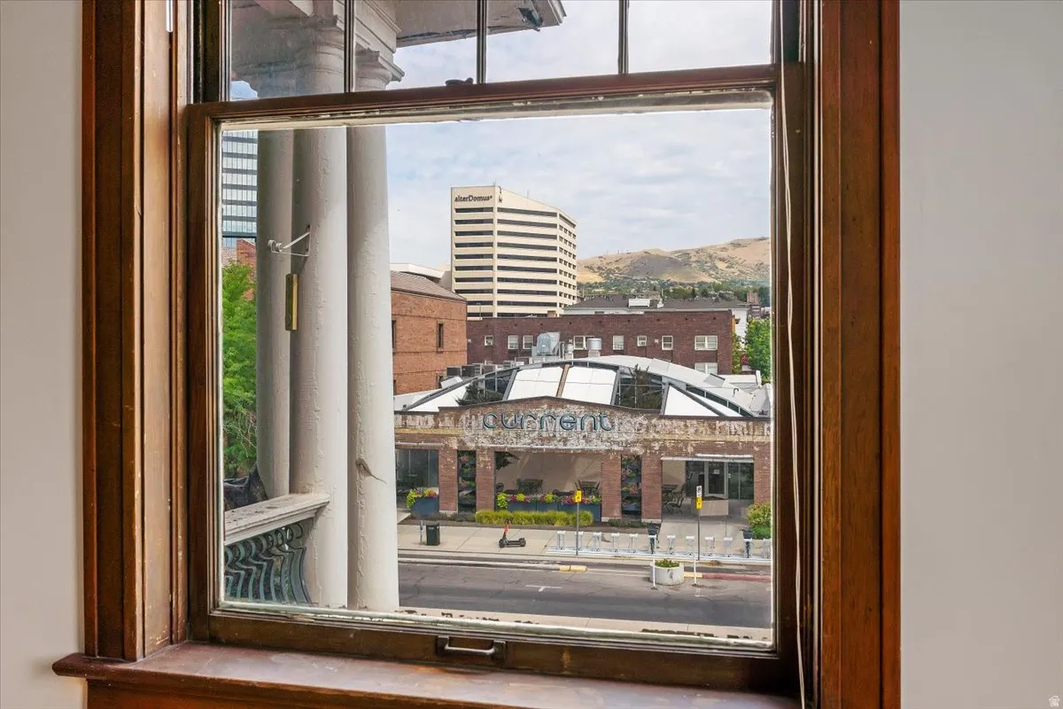 Window framing urban streetscape with distinct architecture and distant mountains