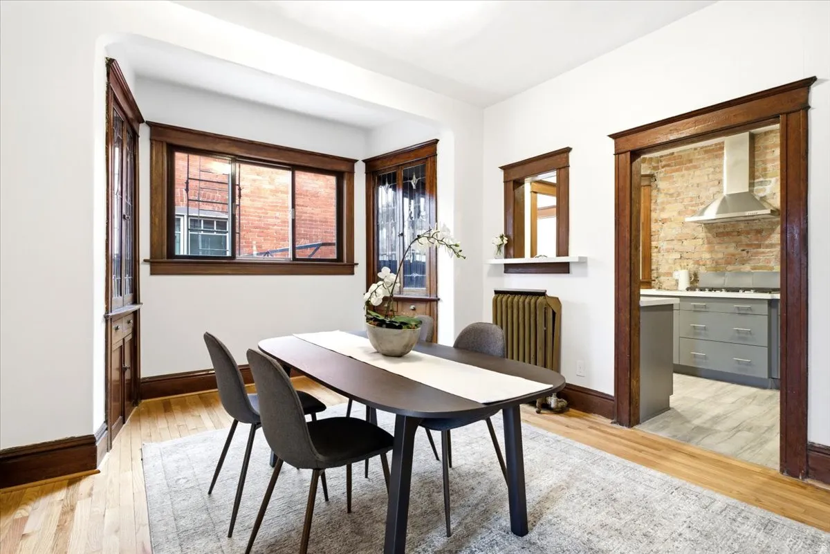 Formal dining space featuring a bay window, hardwood flooring, and rich wood trim