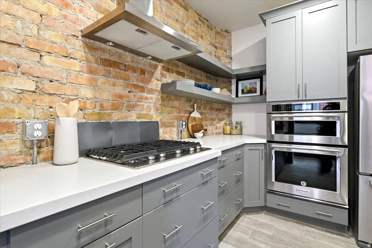 Kitchen featuring exposed brick accent wall