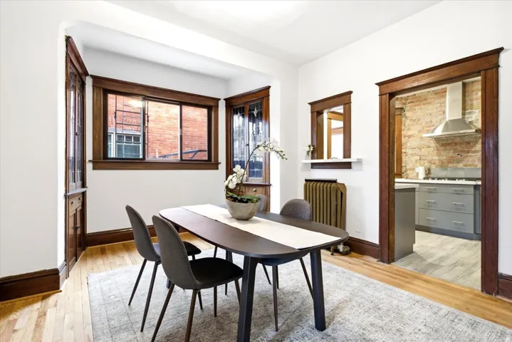Formal dining space featuring a bay window, hardwood flooring, and rich wood trim