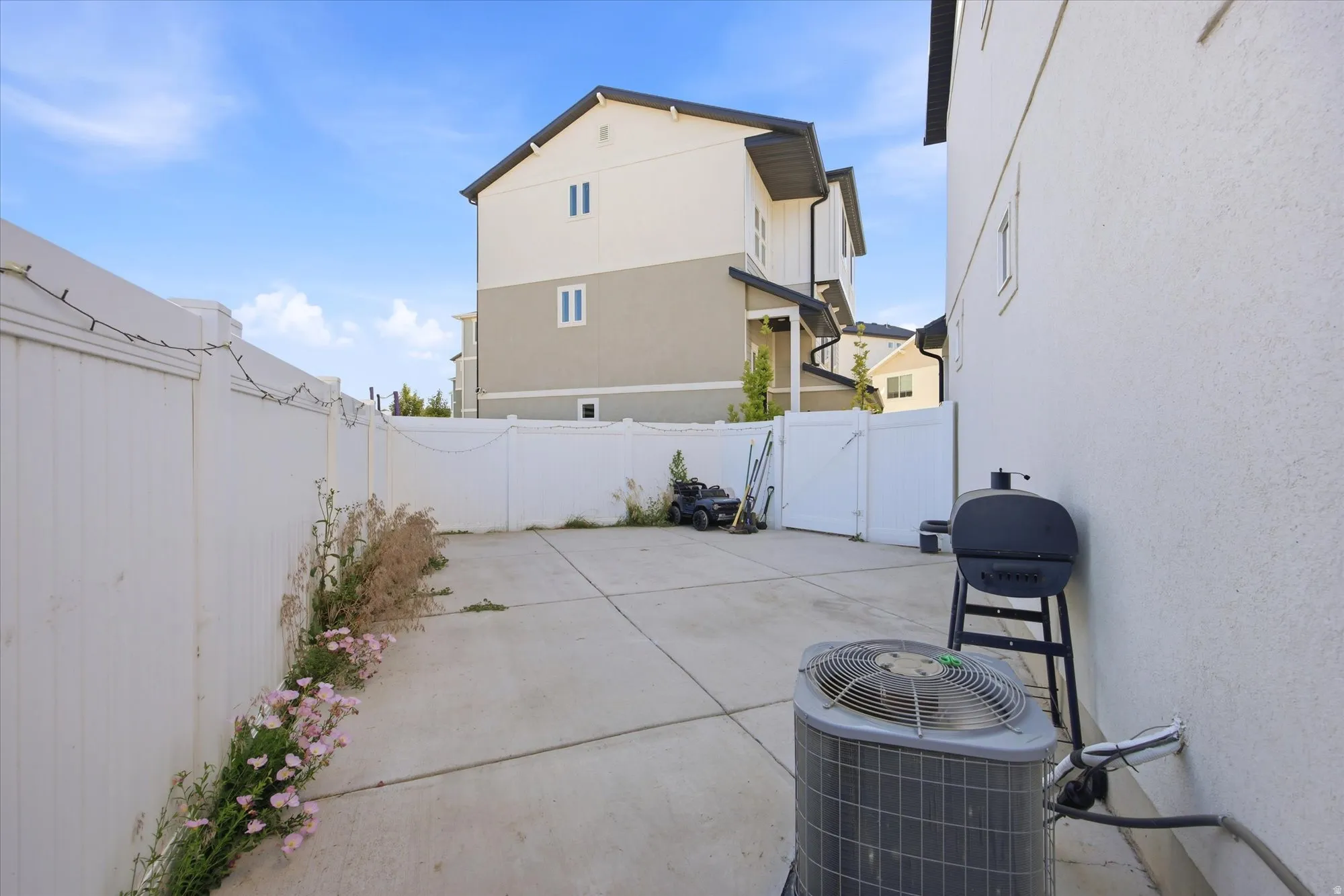 Concrete patio area featuring white fencing