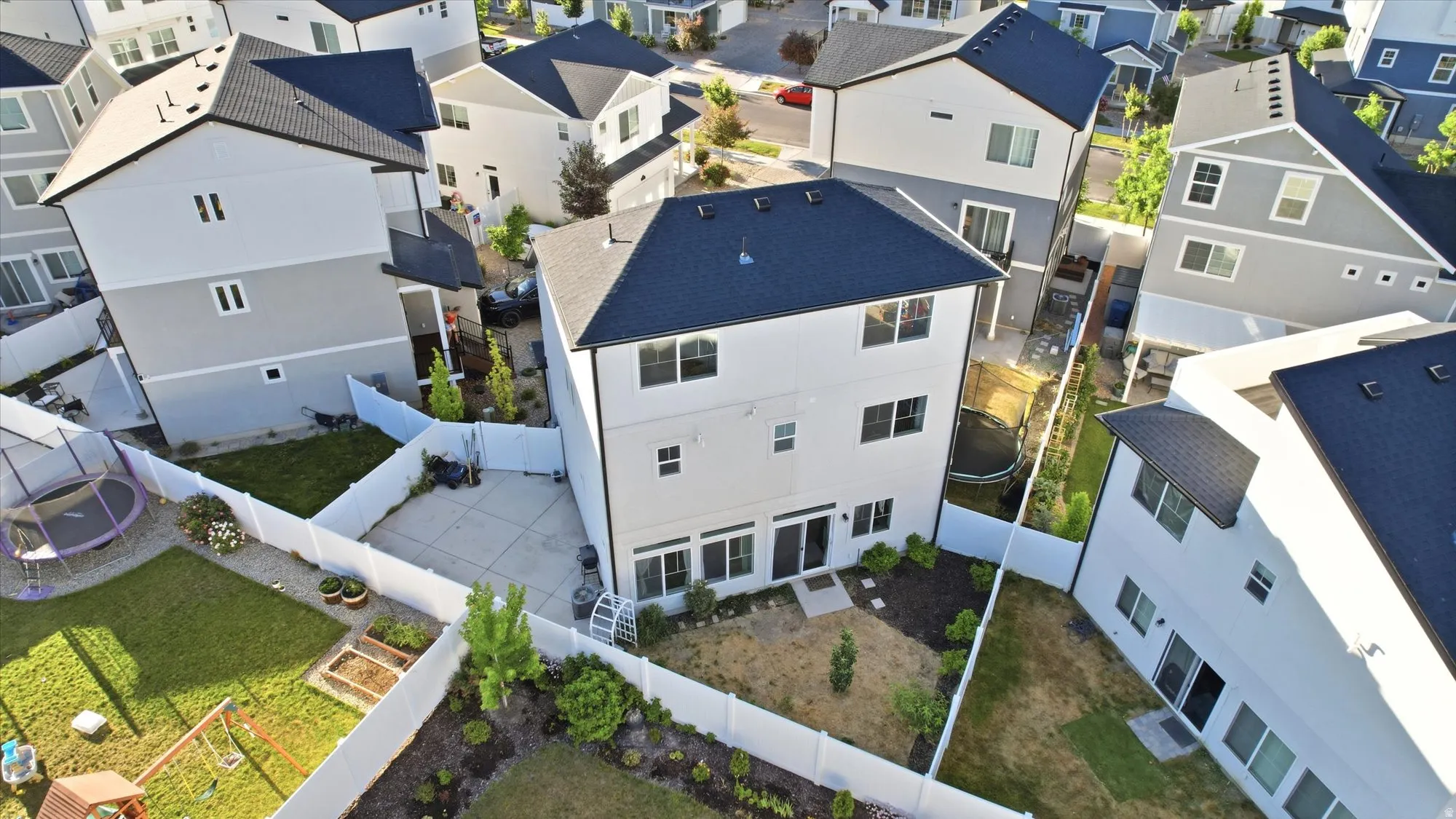 Modern residential architecture featuring a black asphalt shingle roof, white siding, and multiple windows
